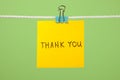 Yellow paper note on clothesline with text Ã¢â¬ÅThank YouÃ¢â¬Â Royalty Free Stock Photo